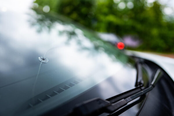 Technician removing a damaged windshield from a car